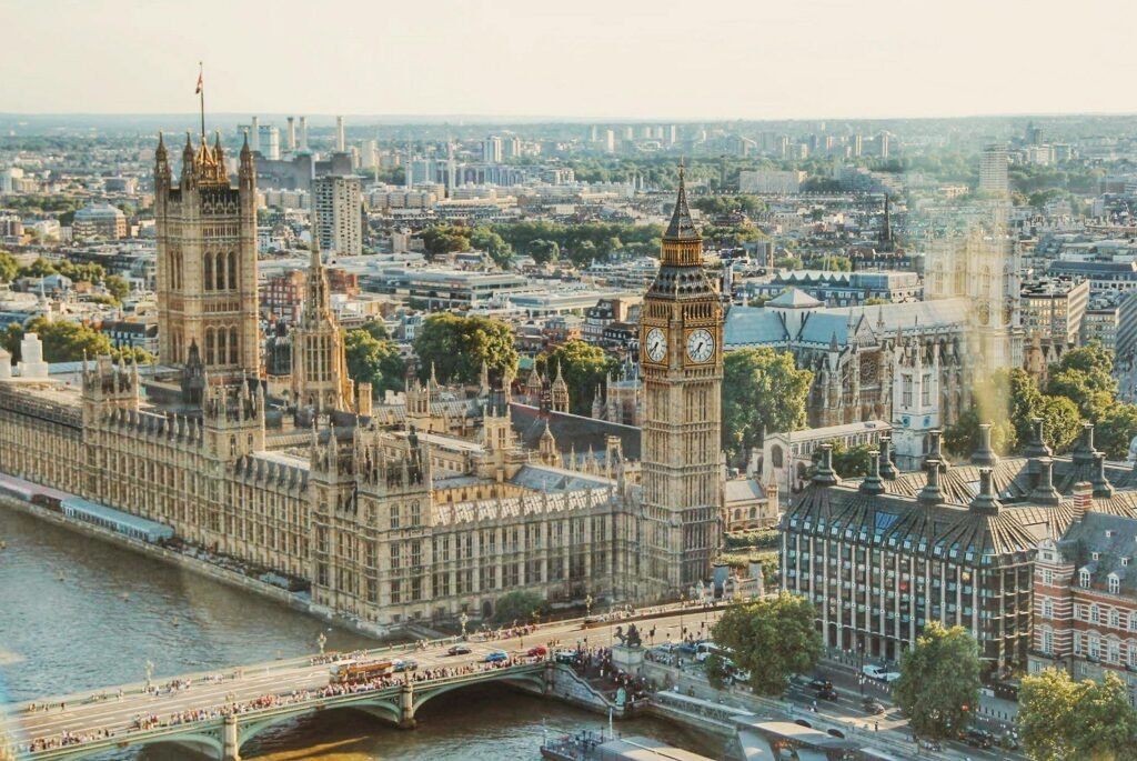 Stunning aerial view of London's iconic Big Ben and the river Thames under daylight.